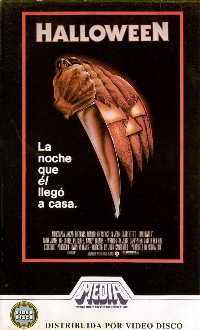 Carátula en VHS de Halloween (1978): una mano con un cuchillo que se convierte en calabaza, con el texto «La noche que él llegó a casa».